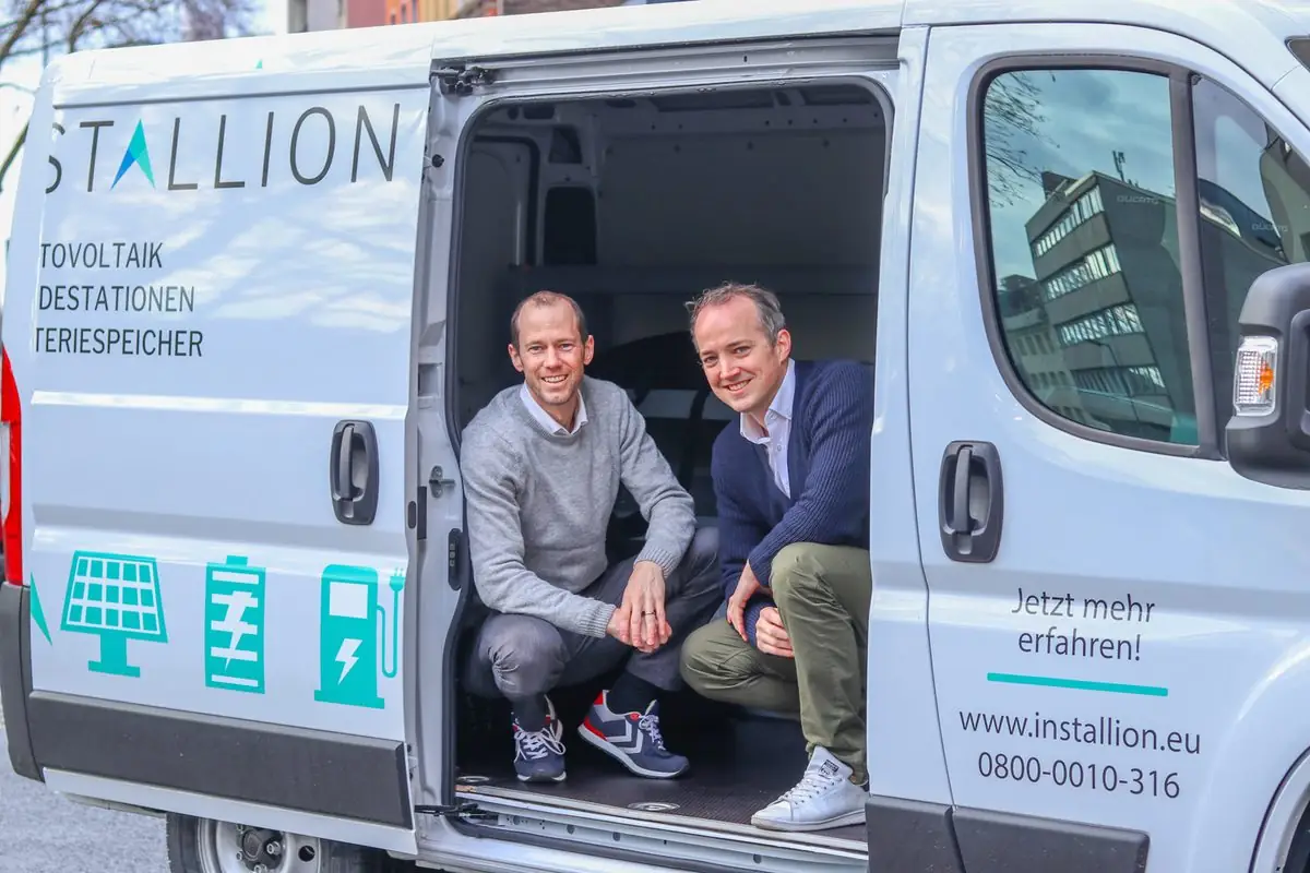 Florian Meyer-Delpho und Till Pirnay in der geöffneten Seitentür eines Installion-Montagefahrzeugs